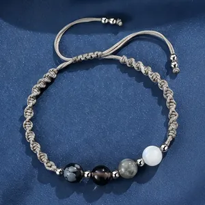 Vista macro del bracciale regolabile intrecciato con perle di pietra di luna e ossidiana