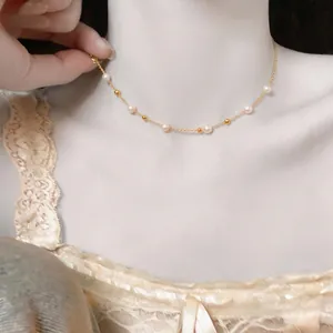 Elegante goldene Halskette im französischen Stil mit zarten weißen Perlen für Damen.