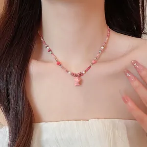 Handmade pink beaded necklace with ceramic dog pendant and pearls on model