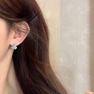 Detailed view of colorful 3D geometric sugar cube earrings worn on a model's ear