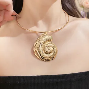 Detailed close-up showing a golden bohemian nautilus shell pendant necklace on a female model