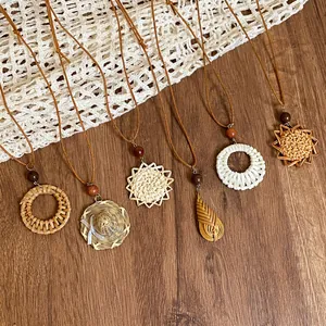 Handgefertigte Anhänger aus geflochtenem Rattan an braunen Lederkordeln im Vintage-Stil.