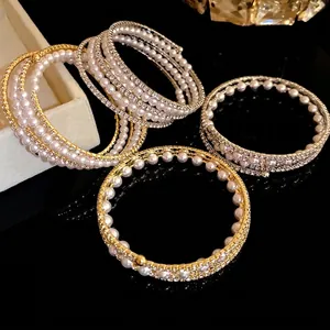Elegant multi-layered open bangle featuring pearls and shimmering rhinestones