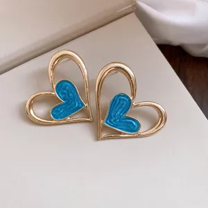 Exquisitos pendientes de corazón dorados con detalle de incrustación de esmalte