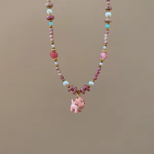 Detailed view of handcrafted beaded necklace with cute pink ceramic puppy pendant