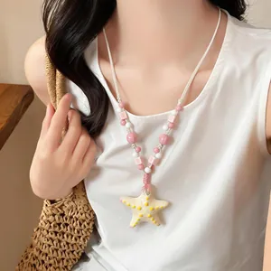 Dettaglio di una collana di perle in ceramica con ciondolo a forma di stella marina gialla