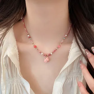 Vibrant pink dopamine style ceramic dog pendant necklace with beads and pearls on model neck