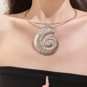 Detail of large silver bohemian conch shell pendant on a thin metal choker.