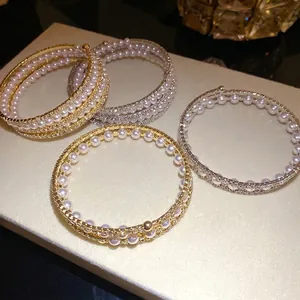 Elegant multilayer open bangle featuring shimmering pearls and sparkling rhinestones