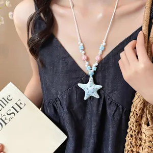 Dettaglio di collana di perline in ceramica con ciondolo a stella marina azzurra