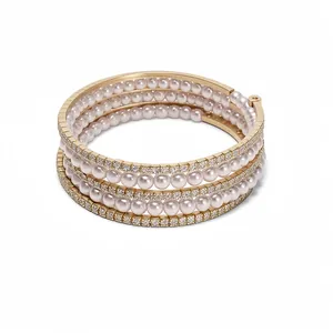 Elegant multi-layer gold bangle bracelet with alternating pearls and sparkling diamonds