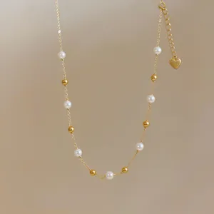 Detaillierte Nahaufnahme einer goldenen Halskette mit weißen Perlen im französischen Stil.