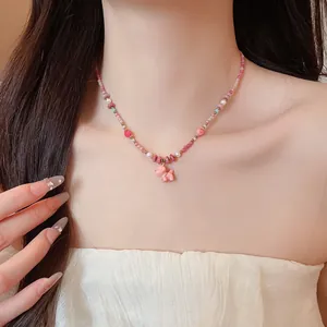 Detail view of dopamine pink beaded necklace with cute ceramic dog pendant on model