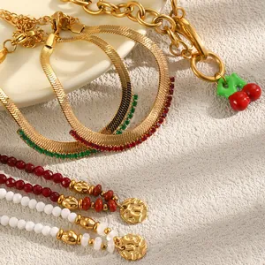Detail of 18K gold plated stainless steel bracelets with colorful beads and cherry charm