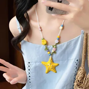 Dettaglio della collana di perline in ceramica colorata con ciondolo a stella.