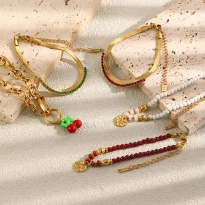 Detailed view of gold-plated bracelets featuring cherry charms and colorful beads on stone.