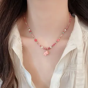 Close-up of dopamine pink beaded necklace with a cute ceramic dog pendant on a model