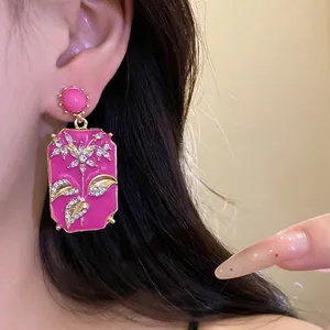 Vintage pink enamel rectangular earrings with floral rhinestone details worn by model