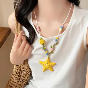 Vista dettagliata di una collana di perle di ceramica a stella marina gialla su una modella