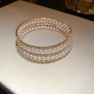 Elegant three-layer gold-tone wrap bracelet with pearls and sparkly rhinestones
