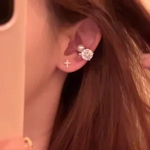 Detailed close-up showing sparkling zircon pearl ear cuff and cross stud earring