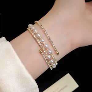 Elegant multi-layer open bracelet featuring white pearls and sparkling rhinestones