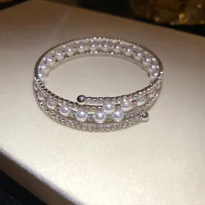 Elegant three-layer silver-tone wrap bracelet with white faux pearls and rhinestones.