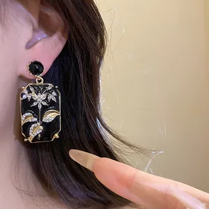Detail shot of vintage style rectangular earrings with black enamel and floral crystal design