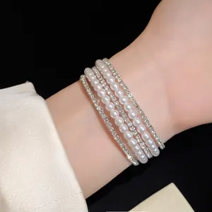Detail shot of an elegant multi-layer bracelet with pearls and rhinestones on the wrist