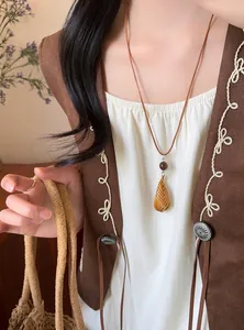 Nahaufnahme von gewebtem Tropfenanhänger an Lederband-Halskette im Vintage-Stil für Damen.