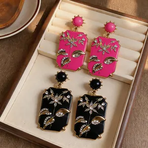 Dettaglio di orecchini pendenti quadrati stile vintage con fiori di strass in un portagioie