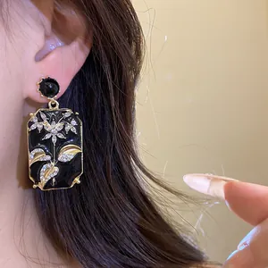 Detailed view of vintage black enamel square earrings with sparkling rhinestones.