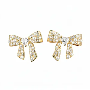 Elegant 18k gold plated bow stud earrings with pearls and heart crystals on white background