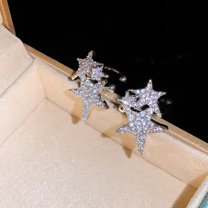 Detailed view of silver star ear cuff with sparkling cubic zirconia on jewelry box