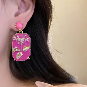 Close-up of vintage pink oil-drop square earrings with rhinestone flower design