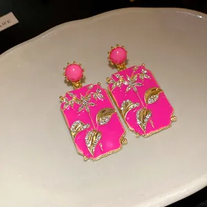 Detailed view of vintage hot pink rectangular enamel earrings featuring crystal floral patterns