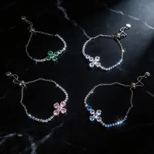 Nahaufnahme von vier verstellbaren Zirkonia-Armbändern mit bunten blumenförmigen Elementen.