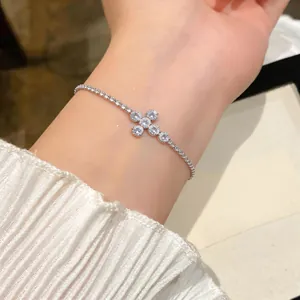 Detailansicht eines eleganten silbernen Armbands mit funkelndem Zirkonia-Kreuz.