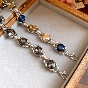 Close-up of vintage silver-tone bracelets with blue and amber faceted zircons