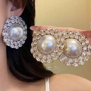 Close-up of luxury vintage round pearl stud earrings with sparkling zircon halo detail