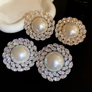 Detailed macro shot of luxury round pearl earrings accented with sparkling zircon stones.