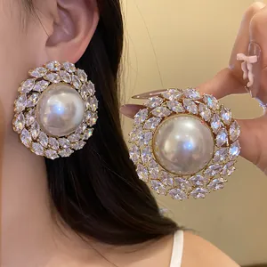 Detail showing large vintage luxury zircon pearl stud earrings with silver needles for women.