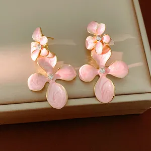 Close-up of pink enamel flower earrings with sparkling rhinestone center on jewelry box