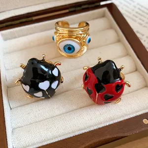 Set of cute ladybug and evil eye open rings in a cream jewelry box