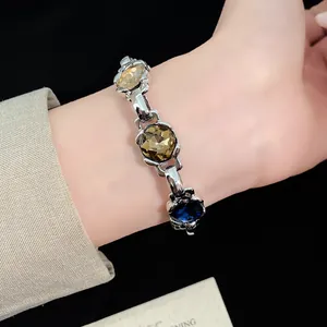 Close-up of vintage rhinstone bracelet with multi-colored faceted stones on wrist.
