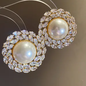 Detailed macro view of elegant zircon pearl stud earrings featuring marquise-cut crystals