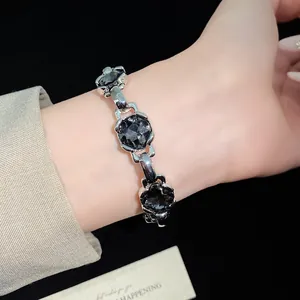 Close-up of a vintage silver-tone bracelet with black multifaceted zircon stones worn on wrist.