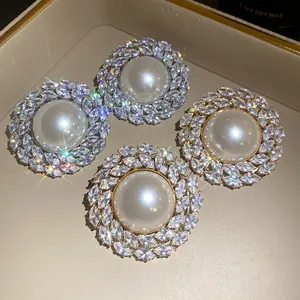 Macro view of vintage round pearl stud earrings with sparkling marquise zirconia halo