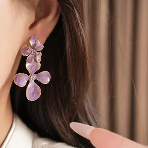Detail of purple flower enamel earrings with center rhinestones and gold edges