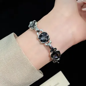 Vintage silver bracelet with dark rhombus zircon stones worn on a woman's wrist
